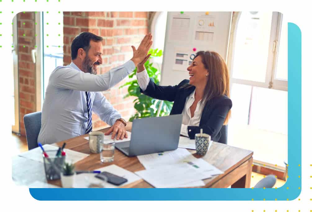 A man and a woman high-fiving in the office